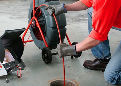 Man inspecting sewer using pipe